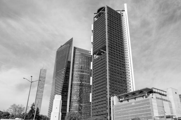 Black and white photo showcasing modern skyscrapers in Mexico City's skyline under a clear sky.